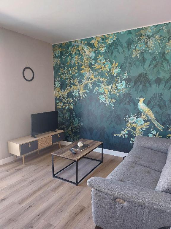 - un salon avec un canapé, une table et un mur dans l'établissement Les rias du Belon, à Riec-sur-Bélon