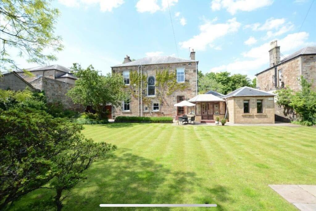 a large house with a large lawn in front of it at Beach lodge with Hot Tub in Ayr