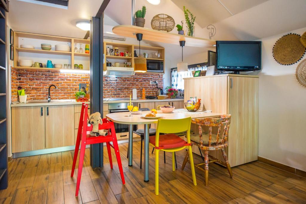 a kitchen with a table and chairs and a tv at Boho House 3 in camp Terme Catez in Čatež ob Savi