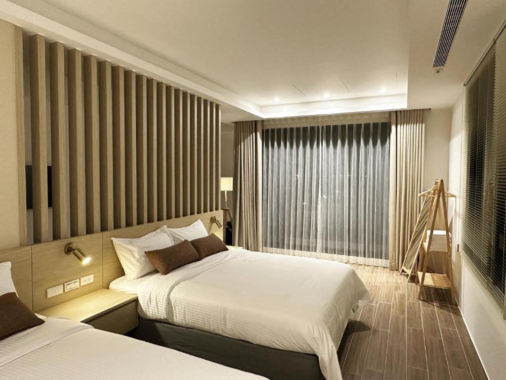 Habitación de hotel con 2 camas y ventana en DOME Homestay, en Dongshan