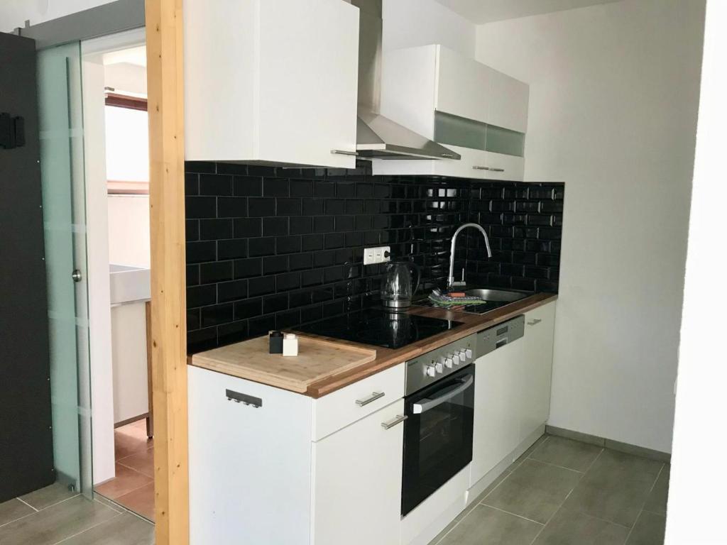 a kitchen with white cabinets and a sink at Ferienapartment Laufen an der Eyach in Albstadt