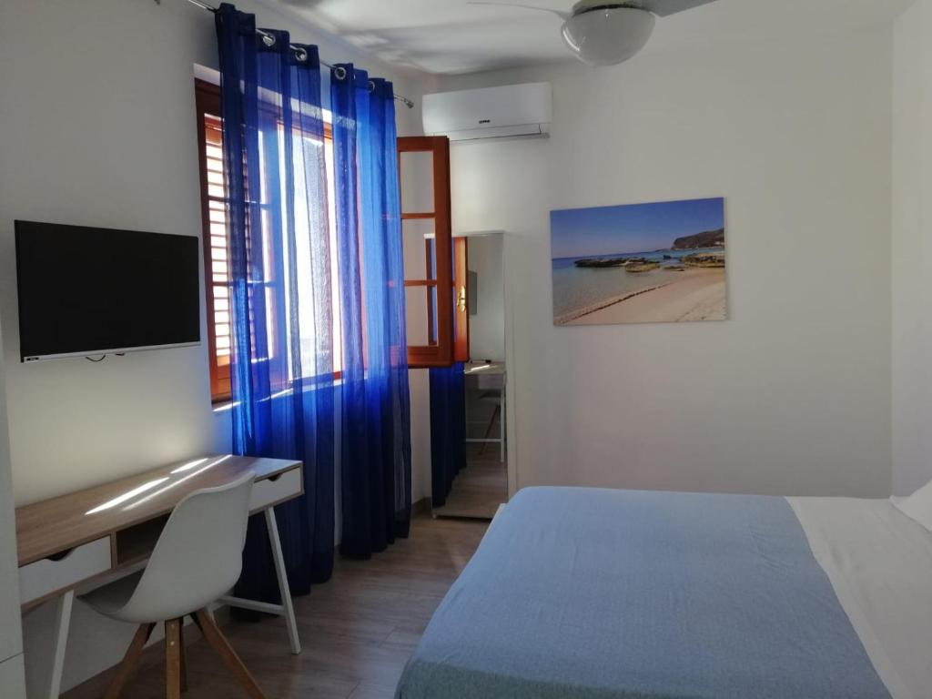 a bedroom with a bed and a desk with a computer at Casa dei Mulini in Favignana