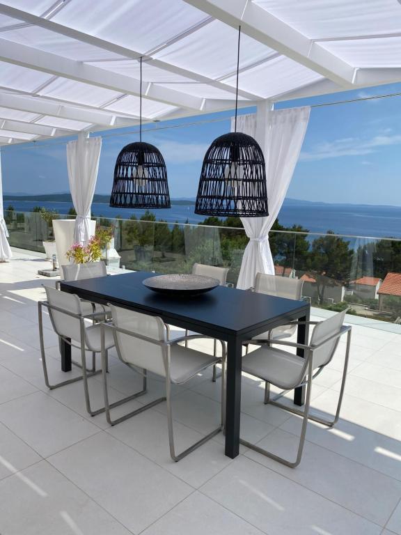 Villa Hvar في إيفان دولاس: طاولة طعام سوداء وكراسي على الفناء