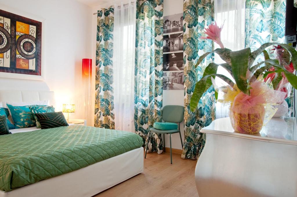 Un dormitorio con una cama verde y una planta en Arena d'Intorno, en Verona