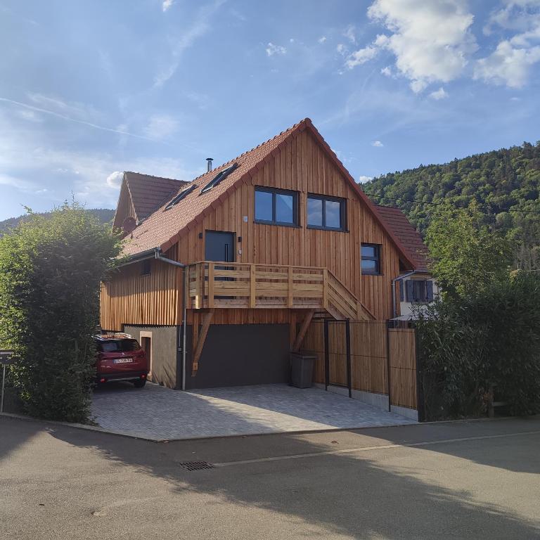 uma grande casa de madeira com uma grande garagem em Les gîtes du Falimont em Stosswihr