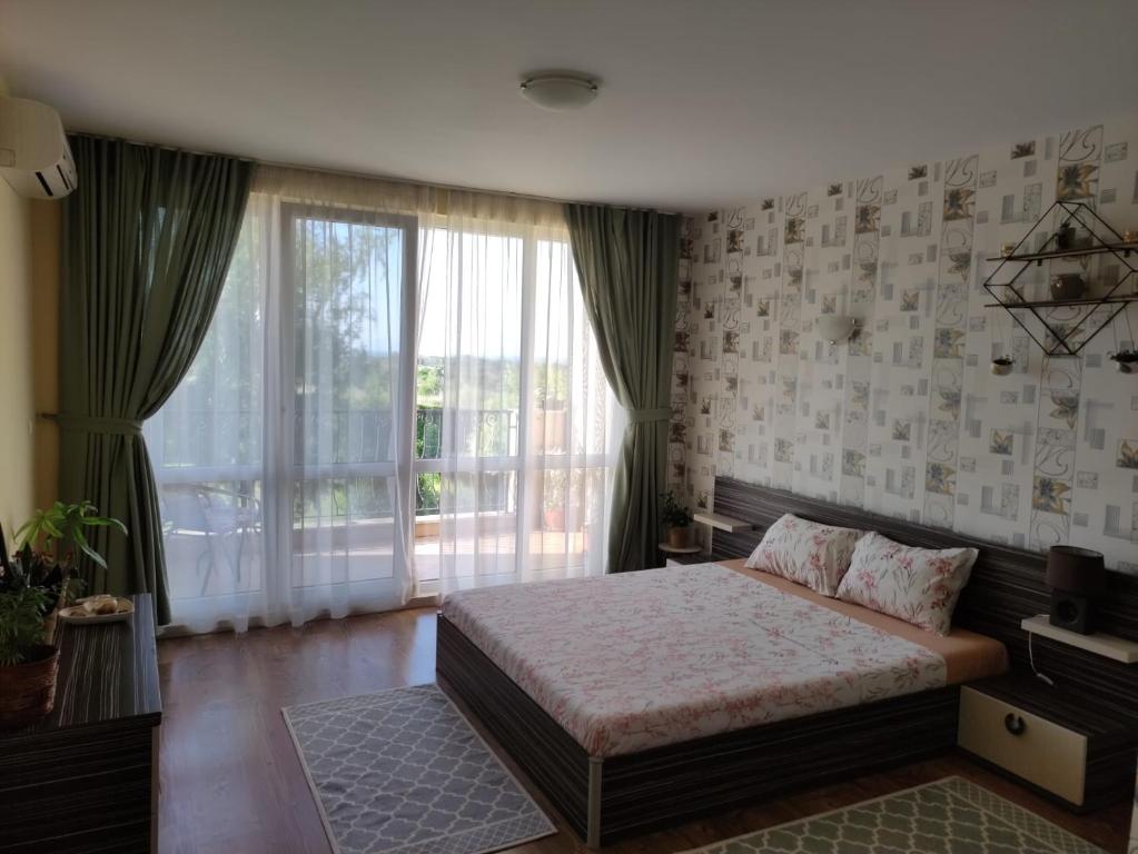 ein Schlafzimmer mit einem Bett und einem großen Fenster in der Unterkunft Apartments Atia Resort in Tschernomorez