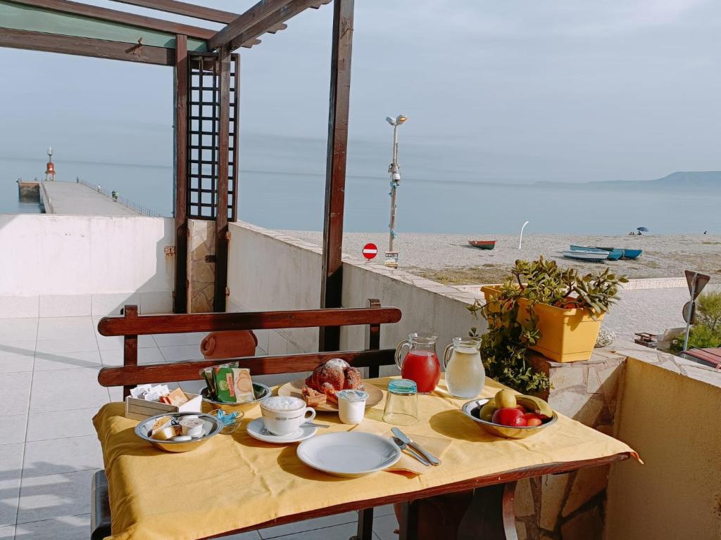 un tavolo con cibo sopra con vista sulla spiaggia di B&B Donna Nina a Gioia Tauro