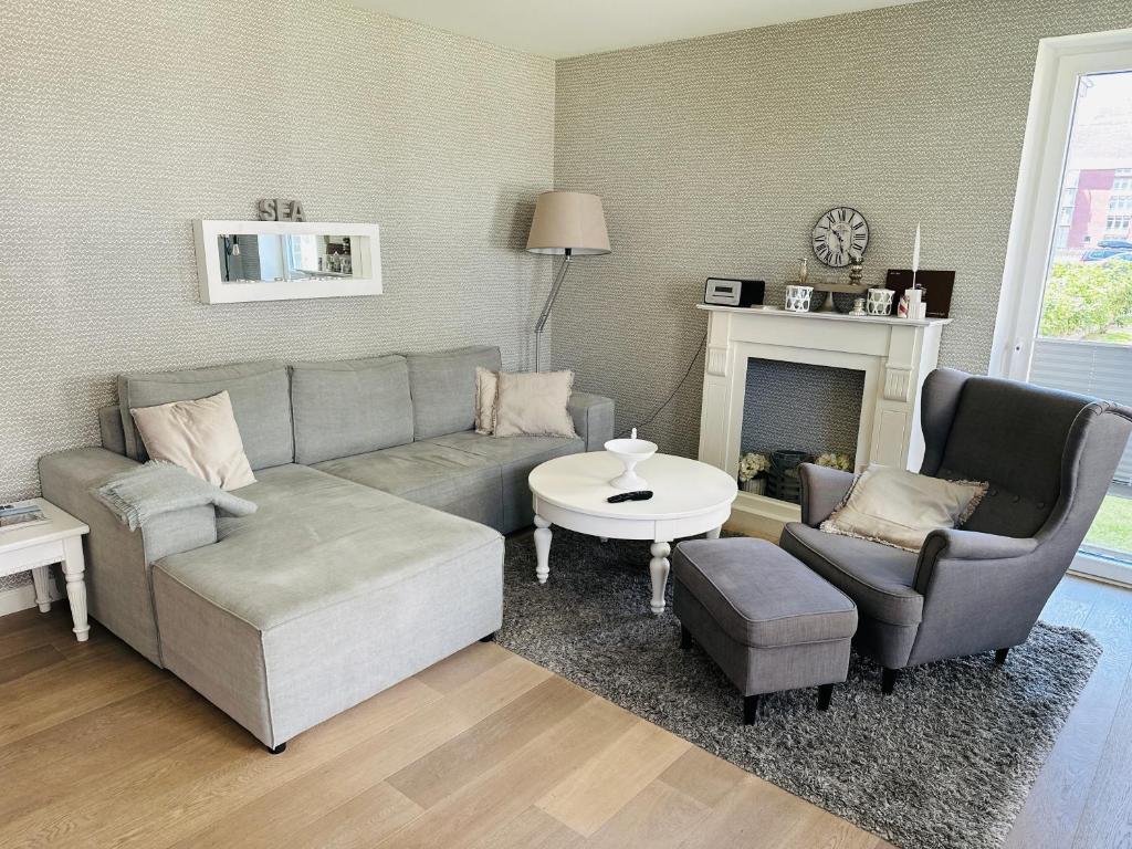 a living room with a couch and chairs and a fireplace at StrandHafen in Westerland