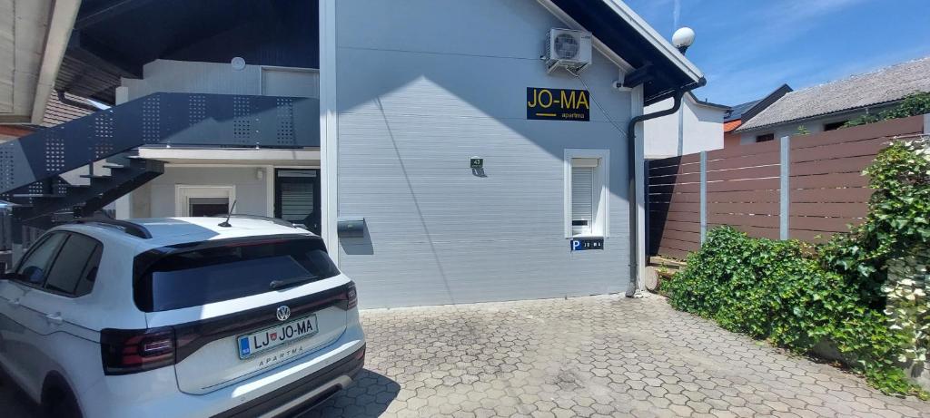 a white car parked in front of a garage at JO-MA apartma - CHRG - station and free parking in Ljubljana