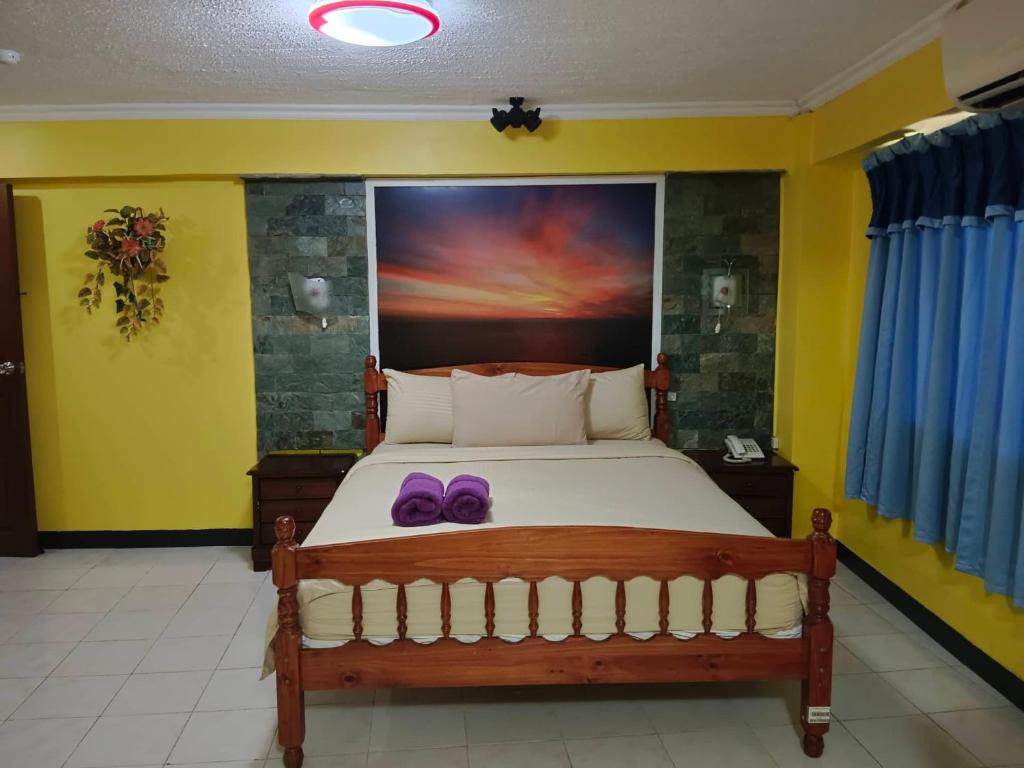 um quarto com uma cama com chinelos roxos em ARIZONA BEACH RESORT em Olongapo