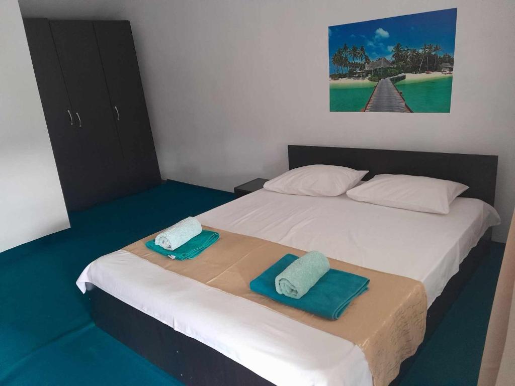 a bedroom with a bed with two towels on it at Casa Octavia in Schitul