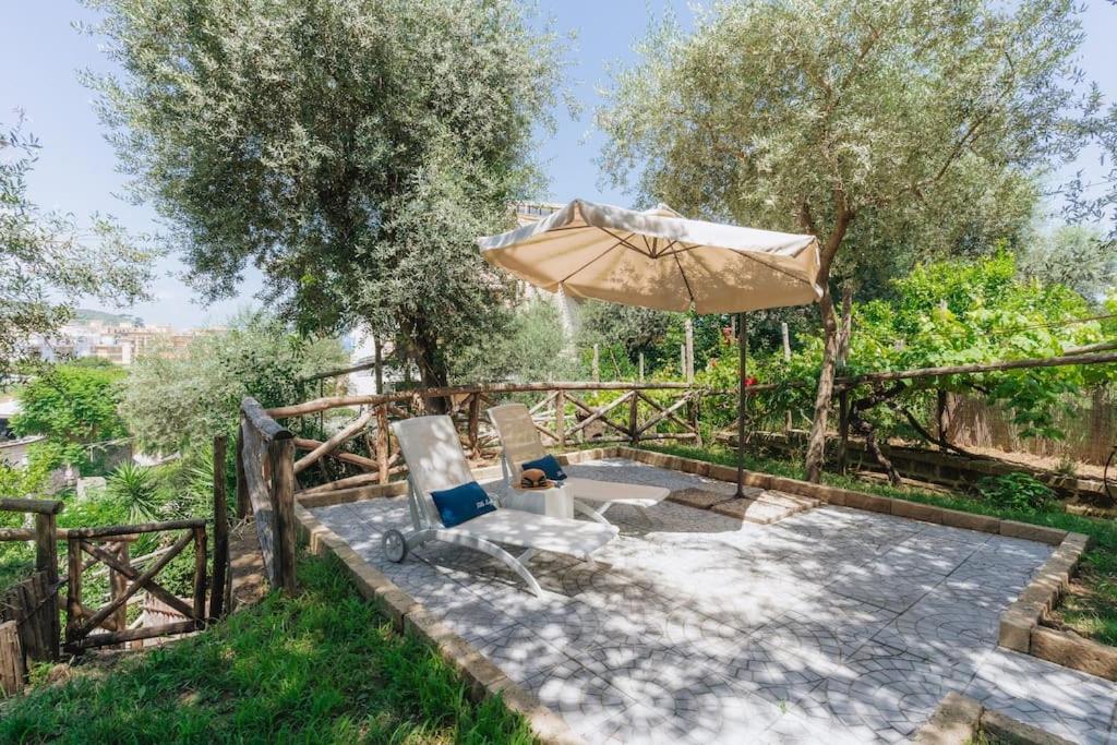 une terrasse avec un parasol, une chaise et une table dans l'établissement Villa Lory, à Sorrente