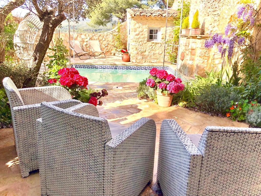 drei Korbstühle auf einer Terrasse neben einem Pool in der Unterkunft L’île aux fleurs in Ventabren