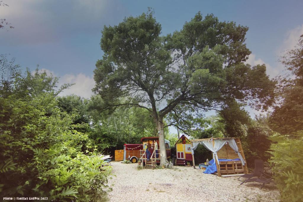 un parque con parque infantil y un árbol en La Roulotte Cavalière, au cœur d'une manade en Camargue, en Mas-Thibert