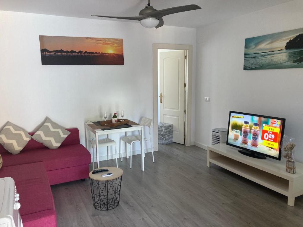 - un salon avec un canapé, une télévision et une table dans l'établissement Apart en fuengirola, à Fuengirola
