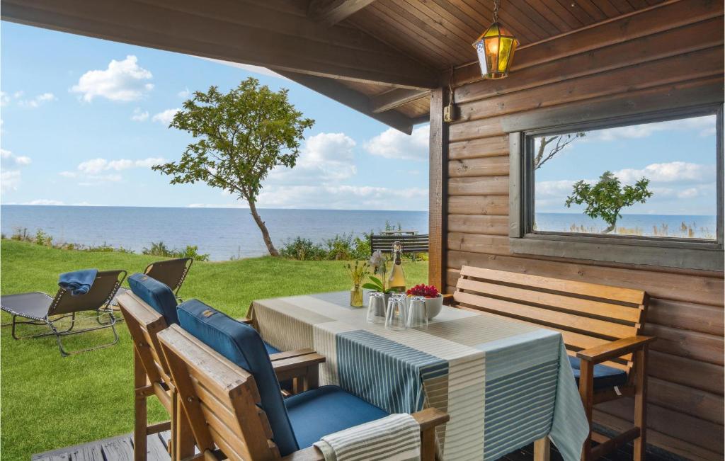 a table and chairs on a patio with a view of the ocean at Beach Front Home In Rnne With Wifi in Rønne
