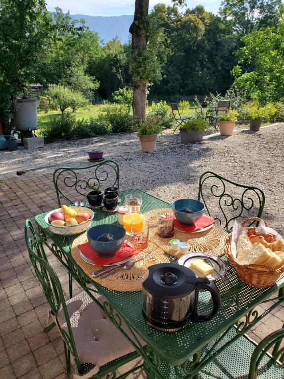una mesa verde con comida y bebidas. en chez Karine en Ceyzérieu