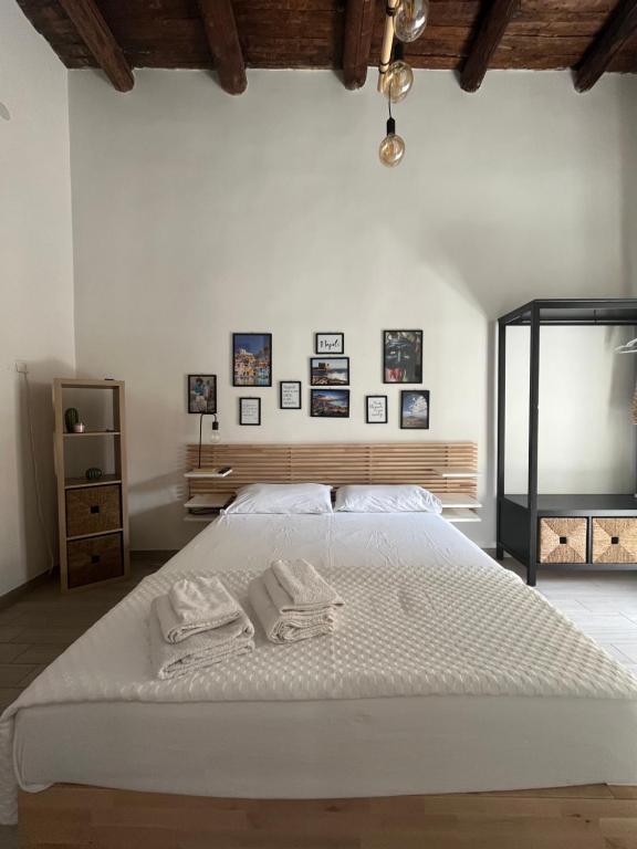 una camera da letto con un grande letto bianco con asciugamani di Borgo Orefici - Napoli Centro a Napoli