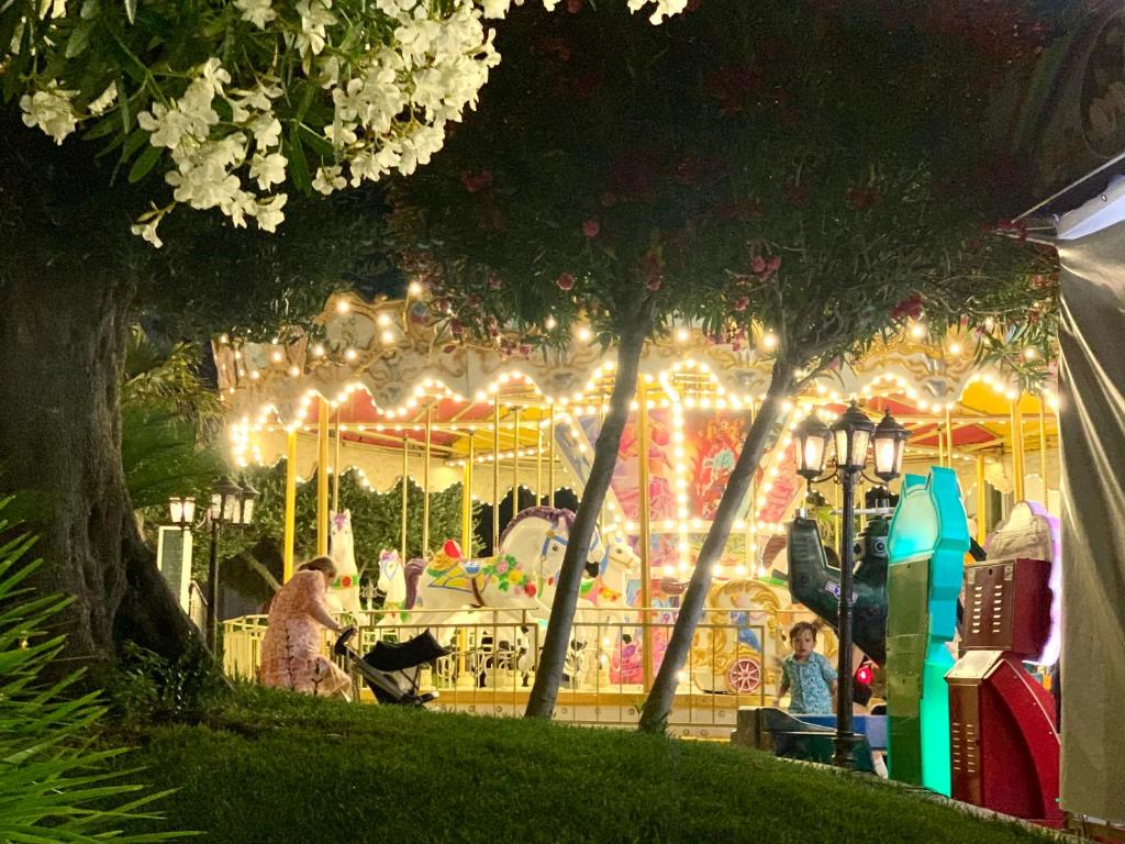 a merry go round at a park at night at Four Seasons Beach Apartment Golem in Golem