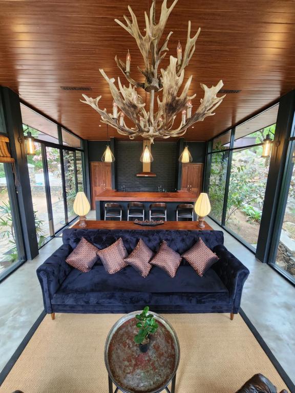 salon z niebieską kanapą i żyrandolem w obiekcie Wild Cassia w mieście Haputale