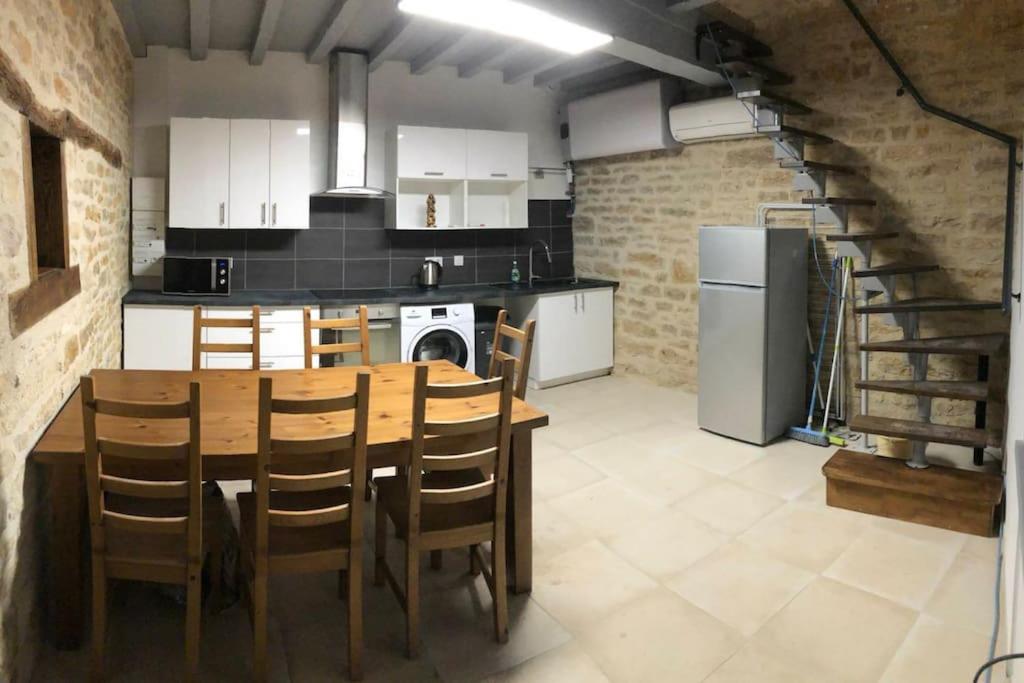 uma cozinha com uma mesa de madeira e uma sala de jantar em superbe appartement avec parking à proximité em Sombernon