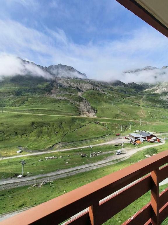 - une vue sur un champ avec une maison et une montagne dans l'établissement Appart 4/6 pers pied des pistes La Mongie, à Bagnères-de-Bigorre