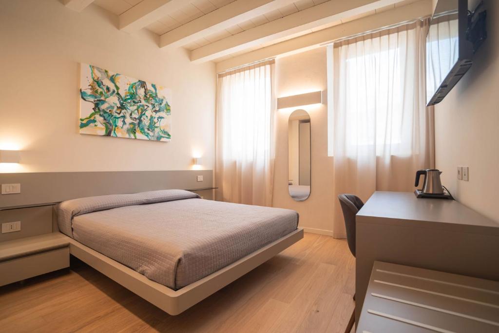 a bedroom with a bed and a desk in it at Maison Calcirelli rooms in Verona
