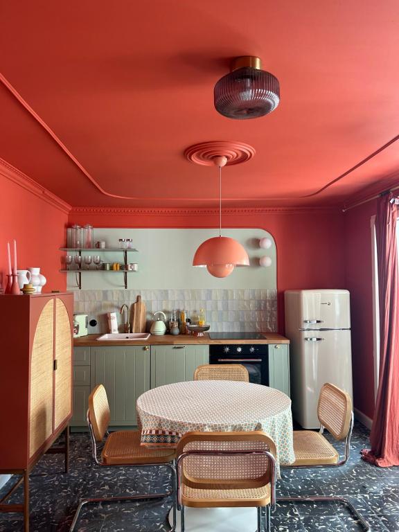 una cucina con pareti rosse, tavolo e sedie di Apartamento No5 a Gandía