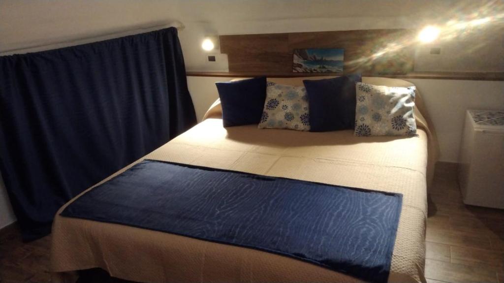 a bedroom with a large bed with blue curtains at Affittacamere il Labirinto in Bisceglie