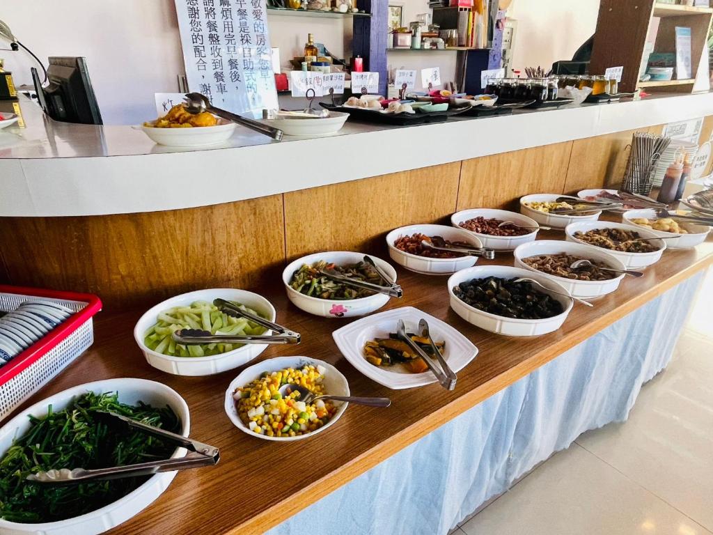 a buffet with many bowls of food on a table at Junyi Landscape Villa in Ren&#39;ai