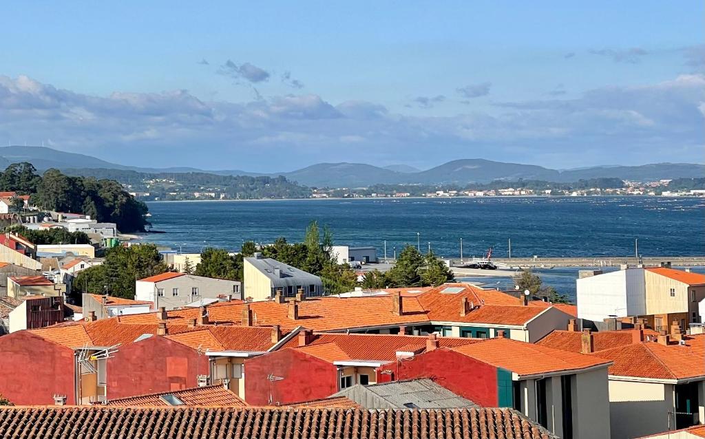 uma vista para uma cidade com telhados vermelhos e o oceano em Piso familiar cerca de playa em Póvoa do Caraminhal