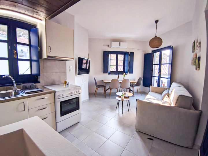 a kitchen and living room with a couch and a table at Oros Eros in Hydra