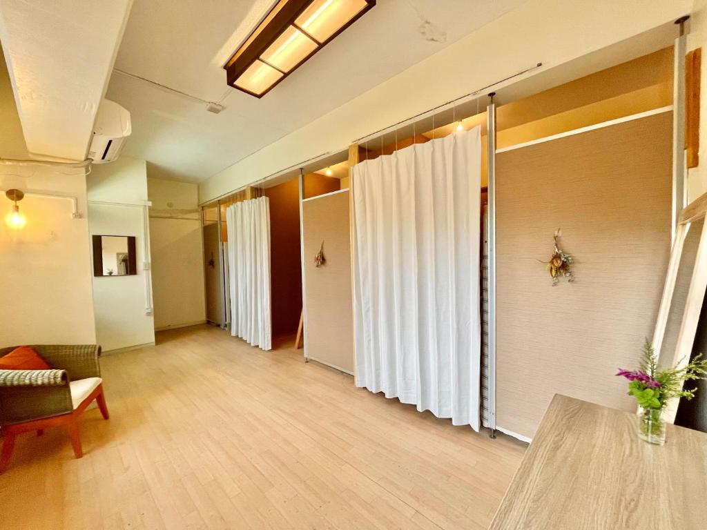 a living room with white curtains and a table at イリワ -stay&coffee iriwa- in Ishigaki Island