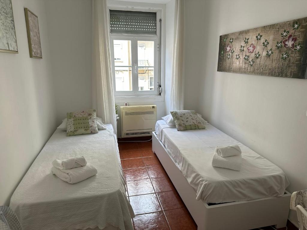 2 camas individuais num quarto com uma janela em Green Charming em Lisboa