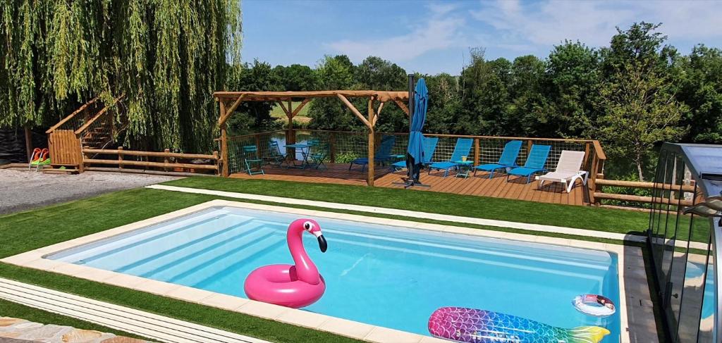 a swimming pool with a pink swan in a yard at Gîte La Terrasse du Loir à 2km du Zoo de la Flèche in La Flèche