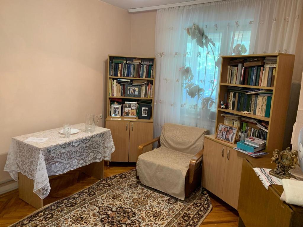 a room with a table and a chair and book shelves at Vila Tatiana in Bîc