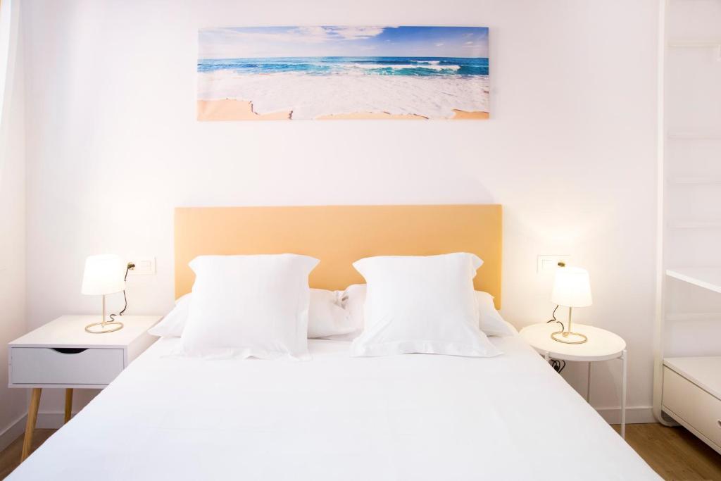 a bedroom with a white bed with two lamps at P4 O Grove Centro Puerto in O Grove