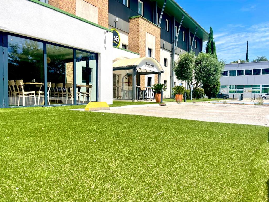 a green lawn in front of a building at B&B HOTEL Aubagne Gémenos in Gémenos