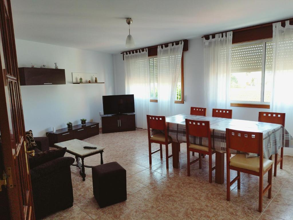 a living room with a dining room table and chairs at Vivienda 2 sin ascensor in Laxe