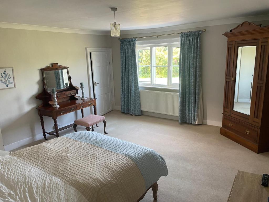 a bedroom with a bed and a tv and a window at Ashmore Farm 