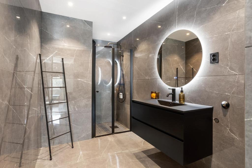 a bathroom with a shower and a sink and a mirror at 2 Bedroom apartment w/ Parking & Balcony in Tønsberg