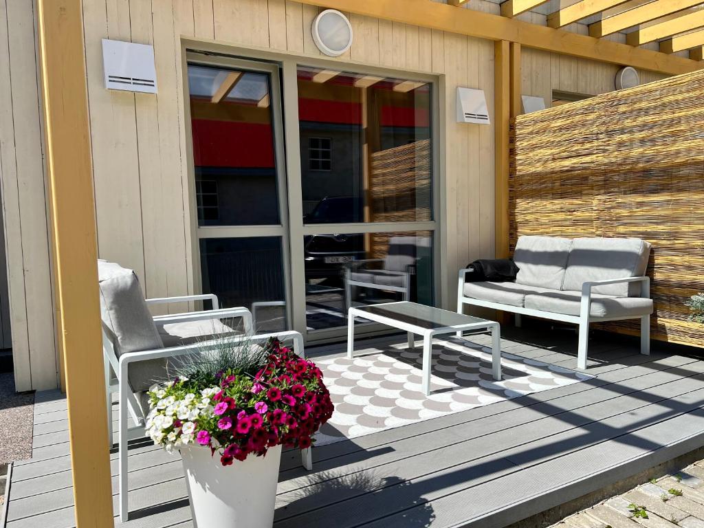 a porch with chairs and a table and flowers at Saue Apartment in Haapsalu