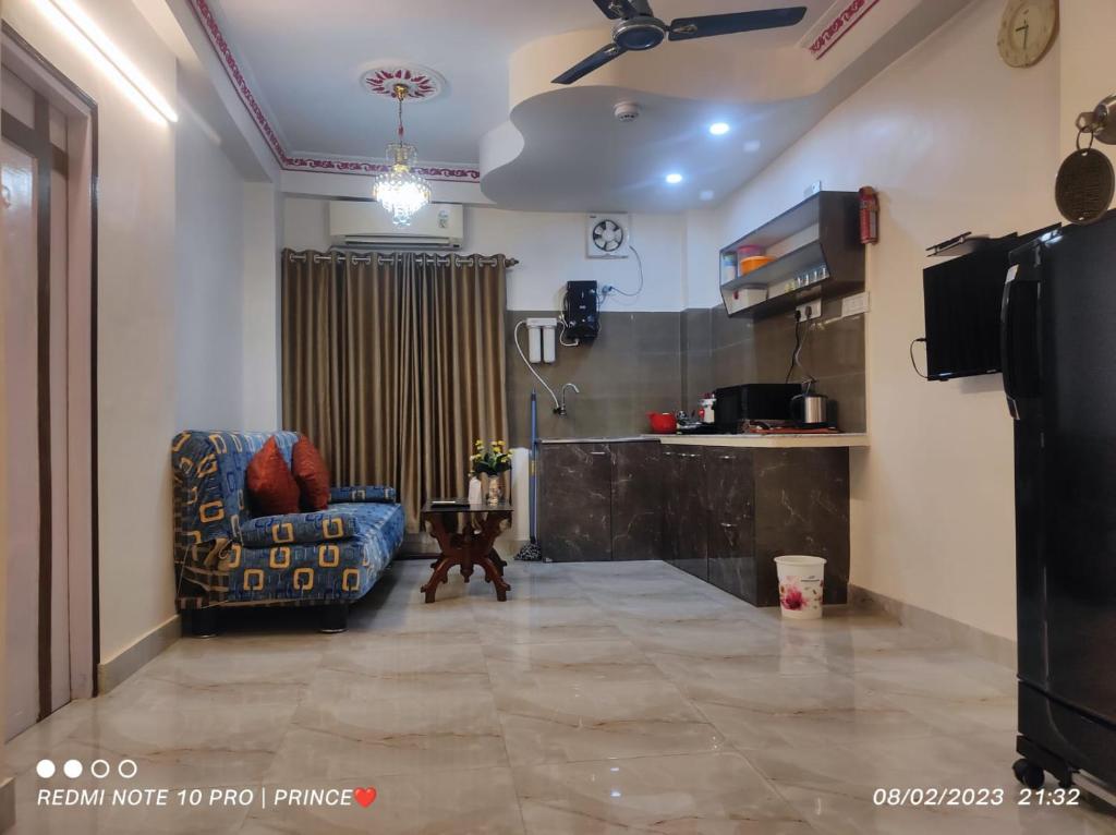 Tulip 1bhk Apartment by Hotel Airways في كولْكاتا: غرفة معيشة مع أريكة وكرسي