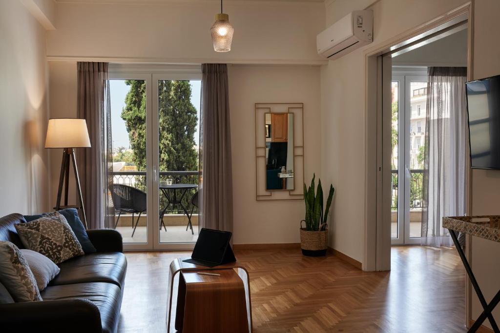 een woonkamer met een bank en een tafel bij Chic One Bd Apartment with Hilton View in Athene