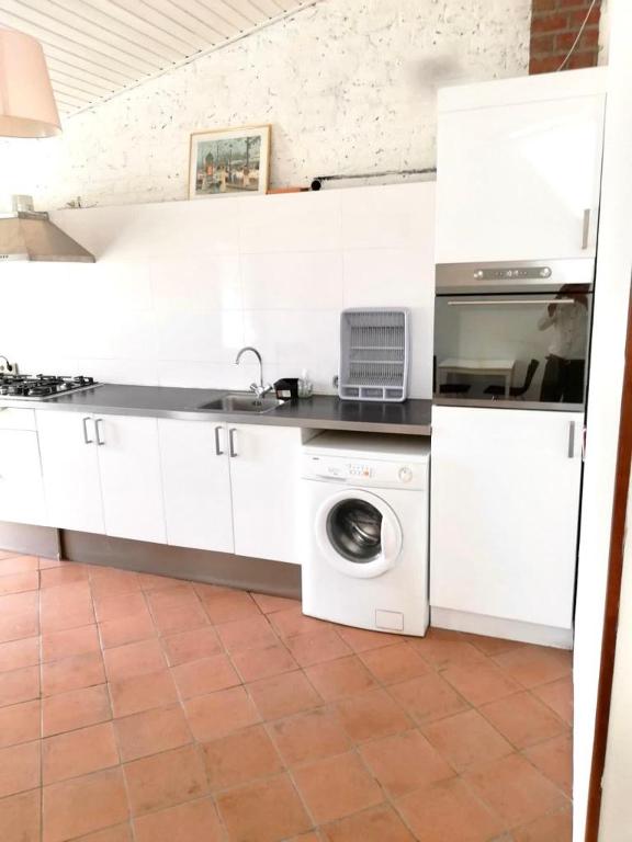 a white kitchen with a washing machine and a sink at Apartment in Nijmegen voor 3 personen in Kranenburg