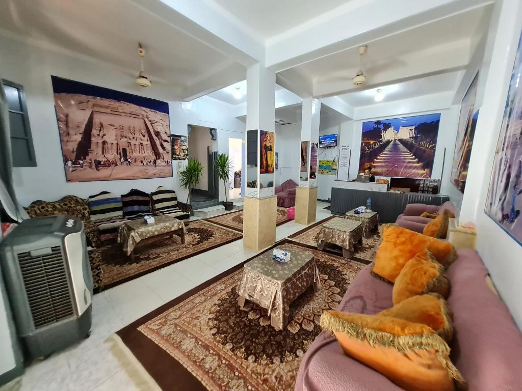 ein großes Wohnzimmer mit Sofas und einem TV in der Unterkunft Grand Hotel &Hostel in Luxor