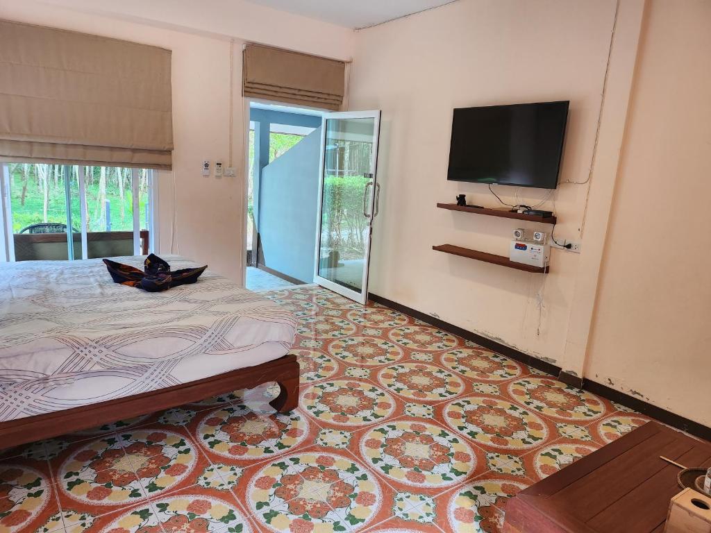 1 dormitorio con 1 cama y TV de pantalla plana en Baan NomTham, en Ko Lanta
