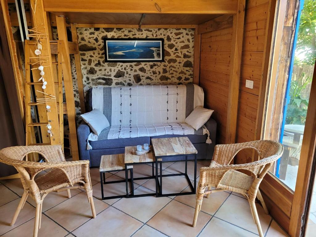 a room with a bed and two chairs and a table at Gîte le Chai in Le Teich