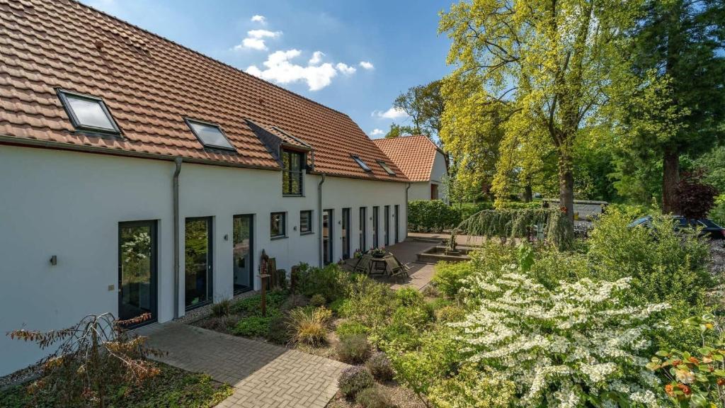 uma casa branca com um jardim em frente em Ferienwohnung Die Traumhafte em Kleve