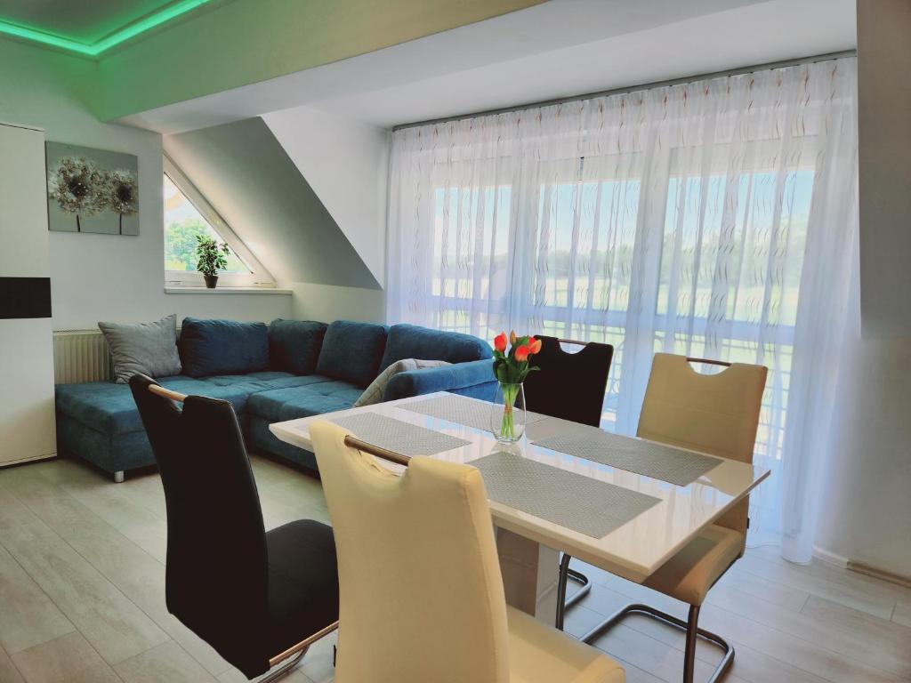 a living room with a table and a blue couch at Heviz Victoria apartman in Hévíz